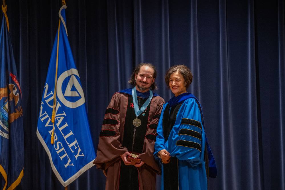 Provost Mili smiles for picture with faculty member